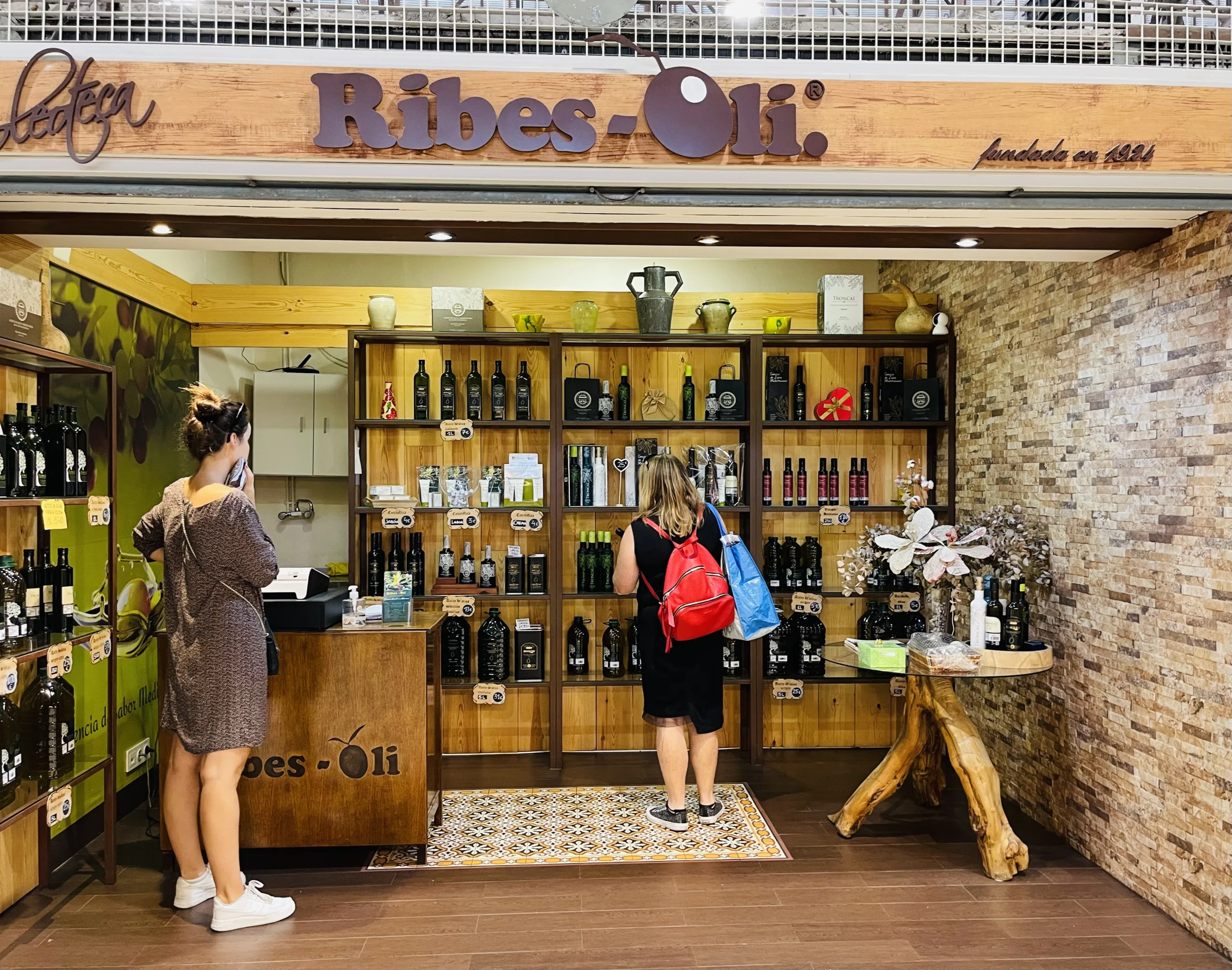 A traditional olive oil stall in the Central Market of Alicante, showcasing an array of premium olive oils in various bottles and containers, emphasizing the rich culinary heritage of the region.
