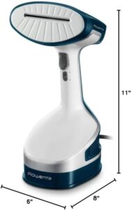 A high-resolution image of the **Rowenta Xcel Steam Travel DR7051** handheld steamer against a **plain white background**, with **size dimensions displayed** around the device. Labels indicate: - **Height: 10 inches (25.4 cm)** - **Width: 5.5 inches (14 cm)** - **Depth: 5 inches (12.7 cm)** - **Weight: 2.5 lbs (1.13 kg)** - **Power Cord Length: 6.5 ft (2 m)** A **side-by-side comparison** with a common object, such as a **water bottle or a hand**, is included to give a clear sense of scale. Dashed measurement lines outline the steamer’s **compact and travel-friendly** design.